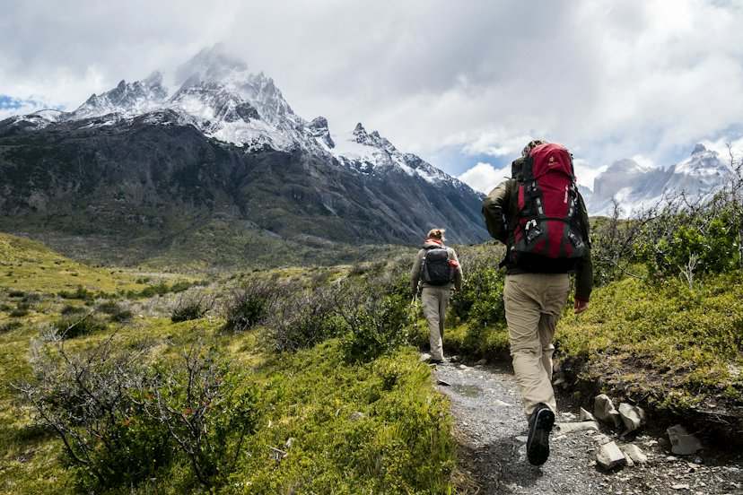 Dos mochileros caminando por un sendero de montaña